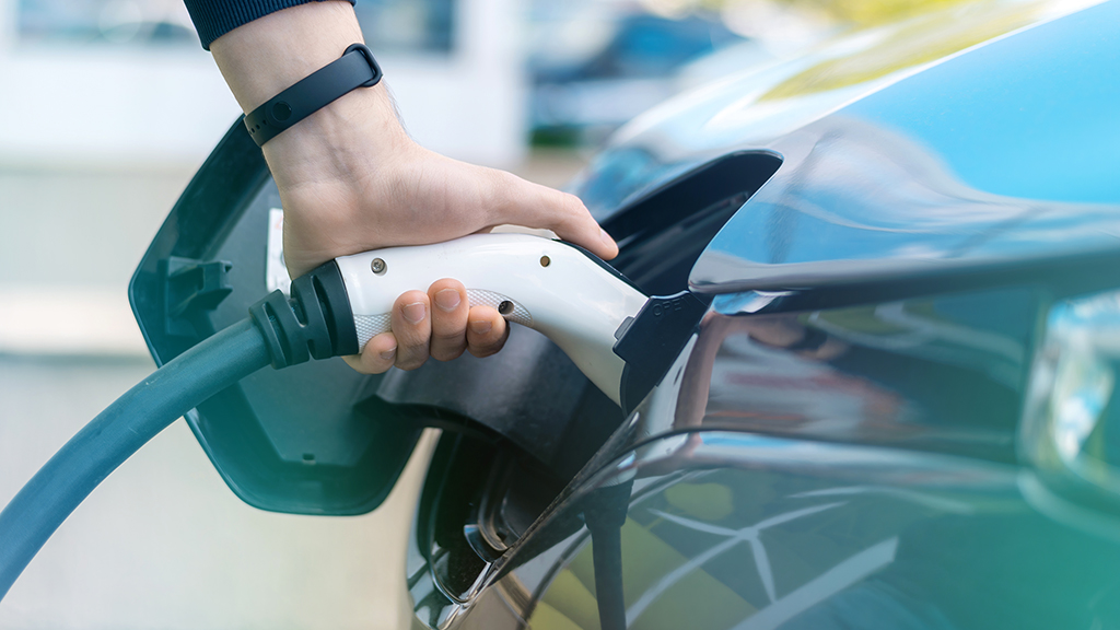 Persona cargando su coche eléctrico