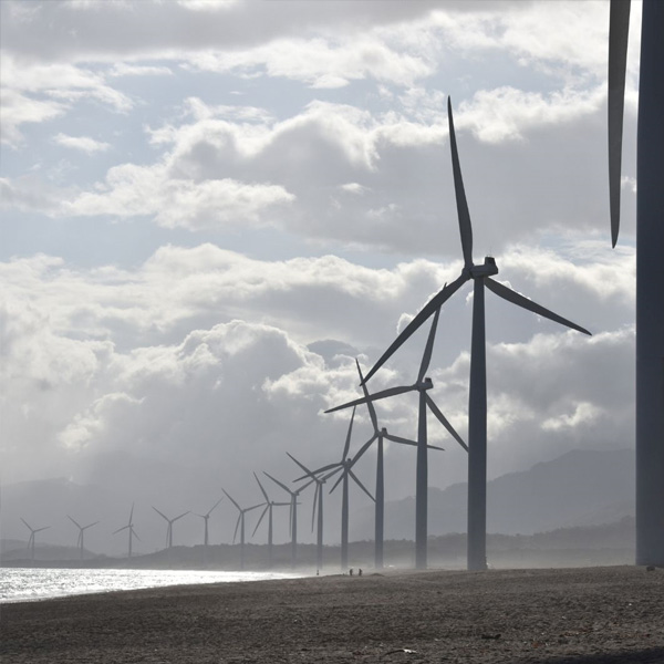 una hilera de molinos de viento sobre un fondo con cielo nuboso