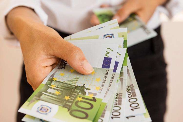 Mano sujetando un fajo de billetes de 100€