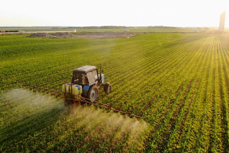 Tractor rociando pesticidas en campo