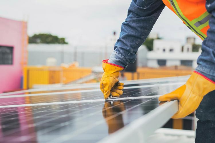 Operario instala una placa fotovoltaica