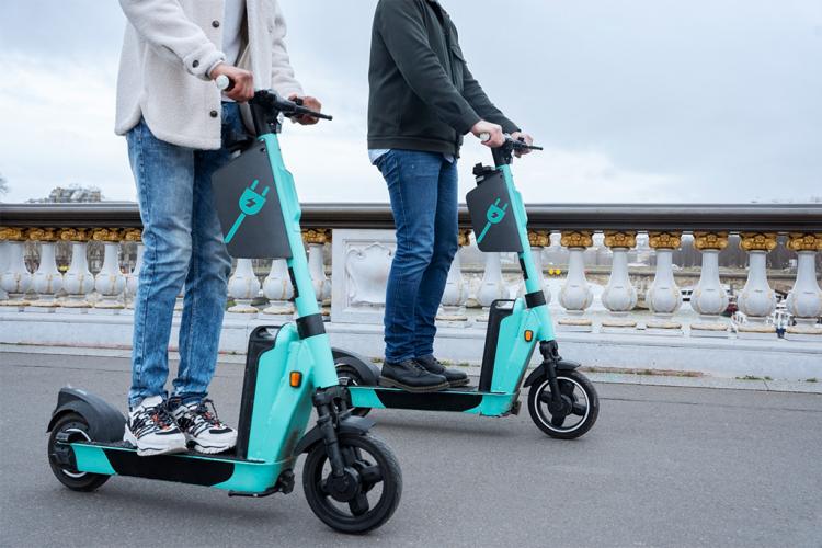 Dos personas adultas sobre patinetes eléctricos