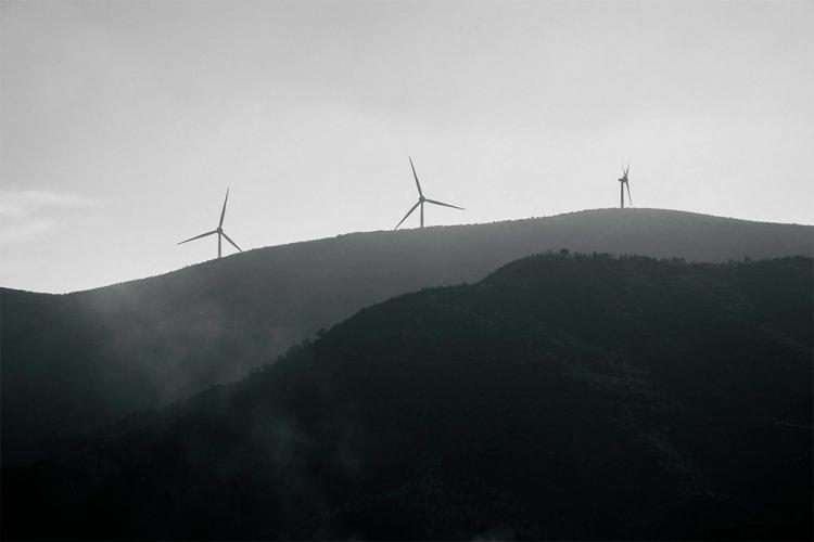 Molinos de viento sobre un monte en un día muy nublado.