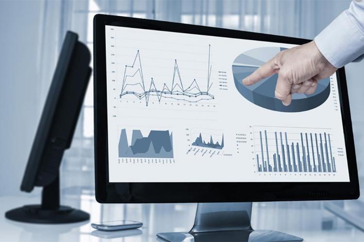 Una mano señalando una pantalla de ordenador con multitud de gráficos.