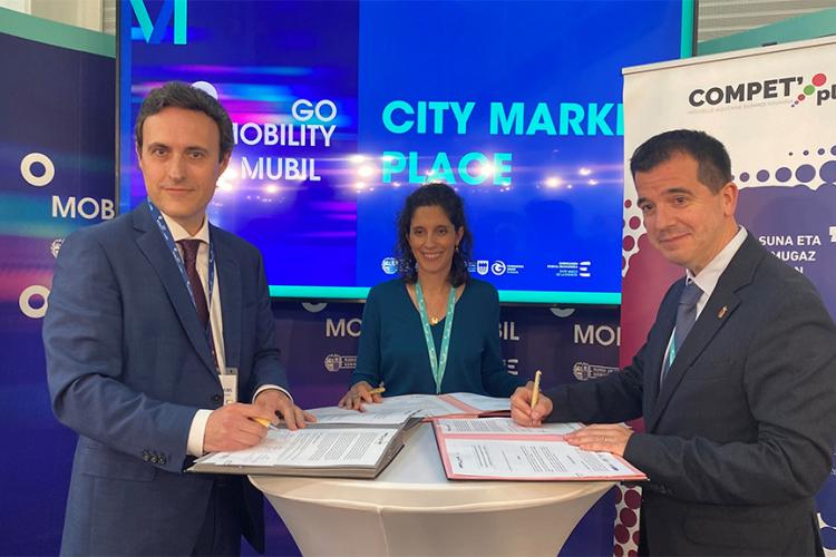 El consejero Irujo; la directora del cluster TOPOS, Camille Coste; y el diputado foral de Promoción Económica, Turismo y Medio Rural y Presidente de MUBIL Fundazioa, Javier Larrañaga, firman el acuerdo en la feria de Go Mobility