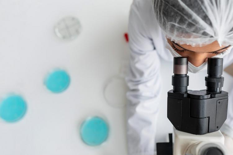 Investigadora de cerca mirando a través de la lente ocular