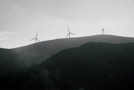 Molinos de viento sobre un monte en un día muy nublado.