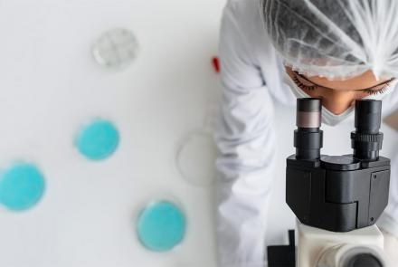 Investigadora de cerca mirando a través de la lente ocular