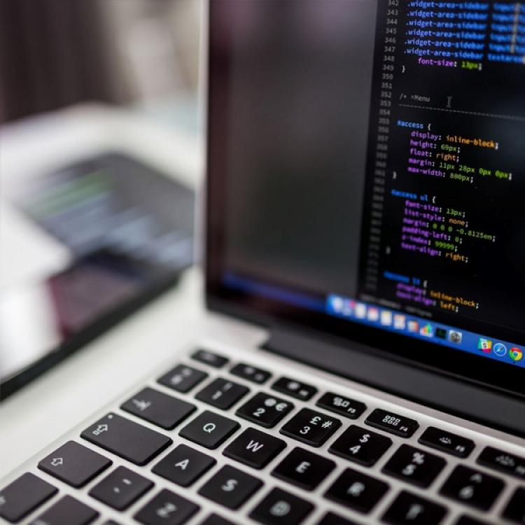 Ordenador portátil con código de programación en la pantalla. 