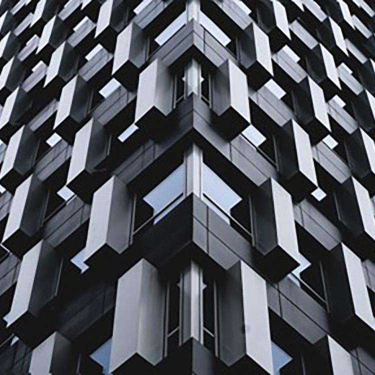 Imagen del exterior de un edificio de oficina. Éste está formado por formas rectangulares sobresalientes de la estructura.